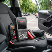 Booster de démarrage AdoreTrip et testeur de batterie posés sur le siège passager d'une voiture